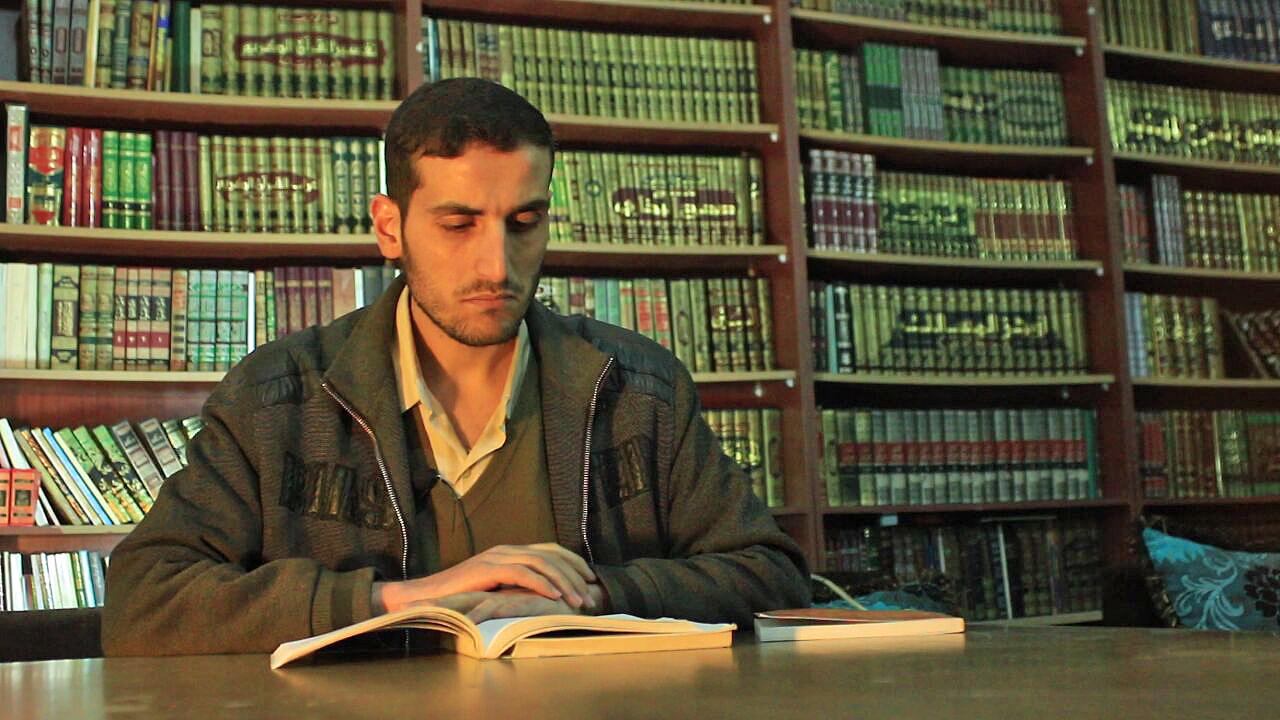 Anas Habib czyta książkę w tajnej bibliotece w Syrii