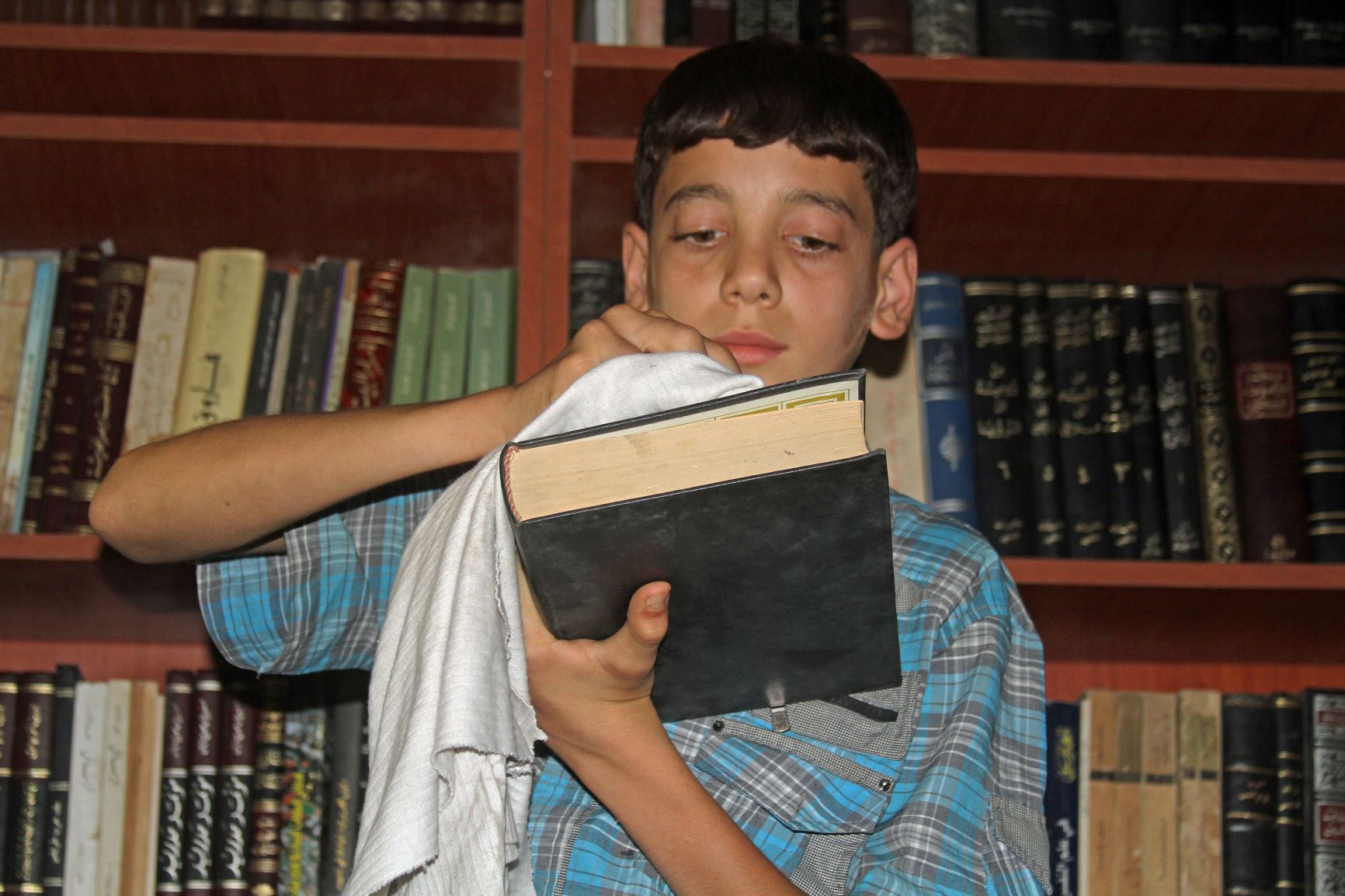 14-letni Amjad czyści książkę z tajnej syryjskiej biblioteki 
