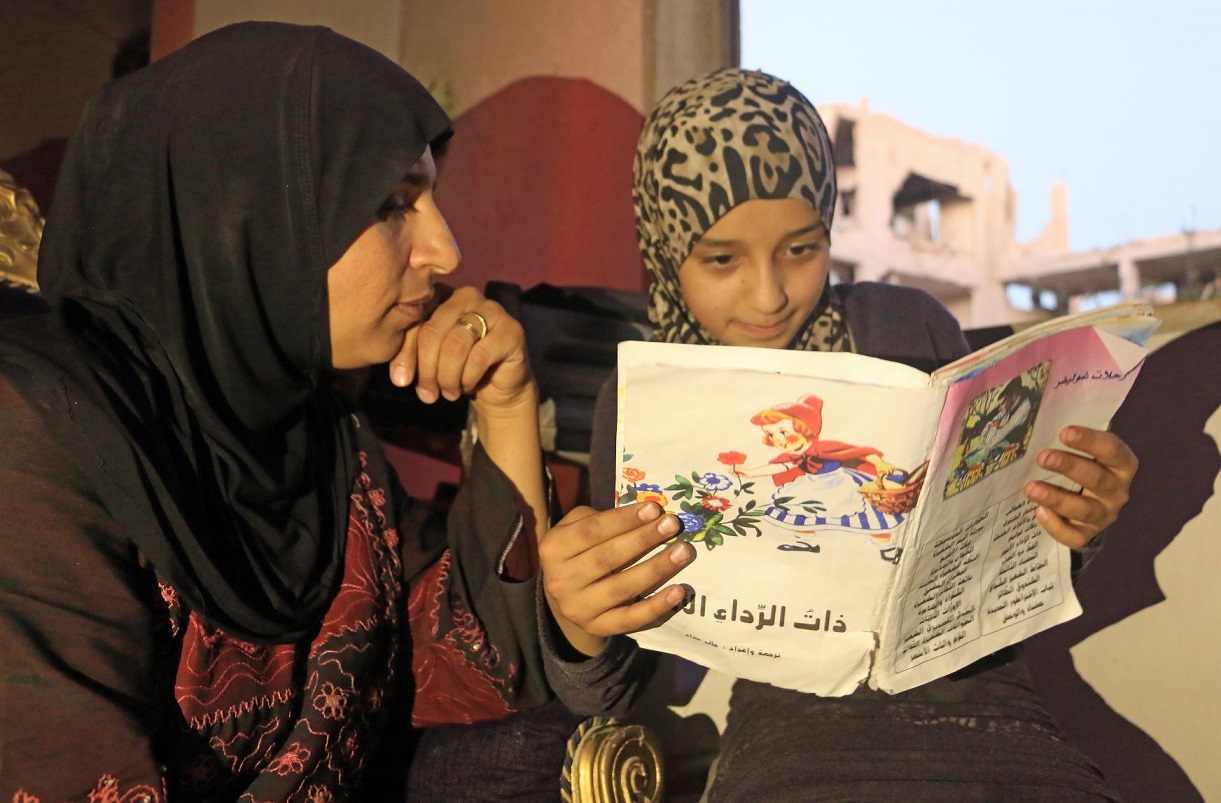 Czytelniczki biblioteki, Saleema i jej 12-letnia córka Islam oglądają książkę